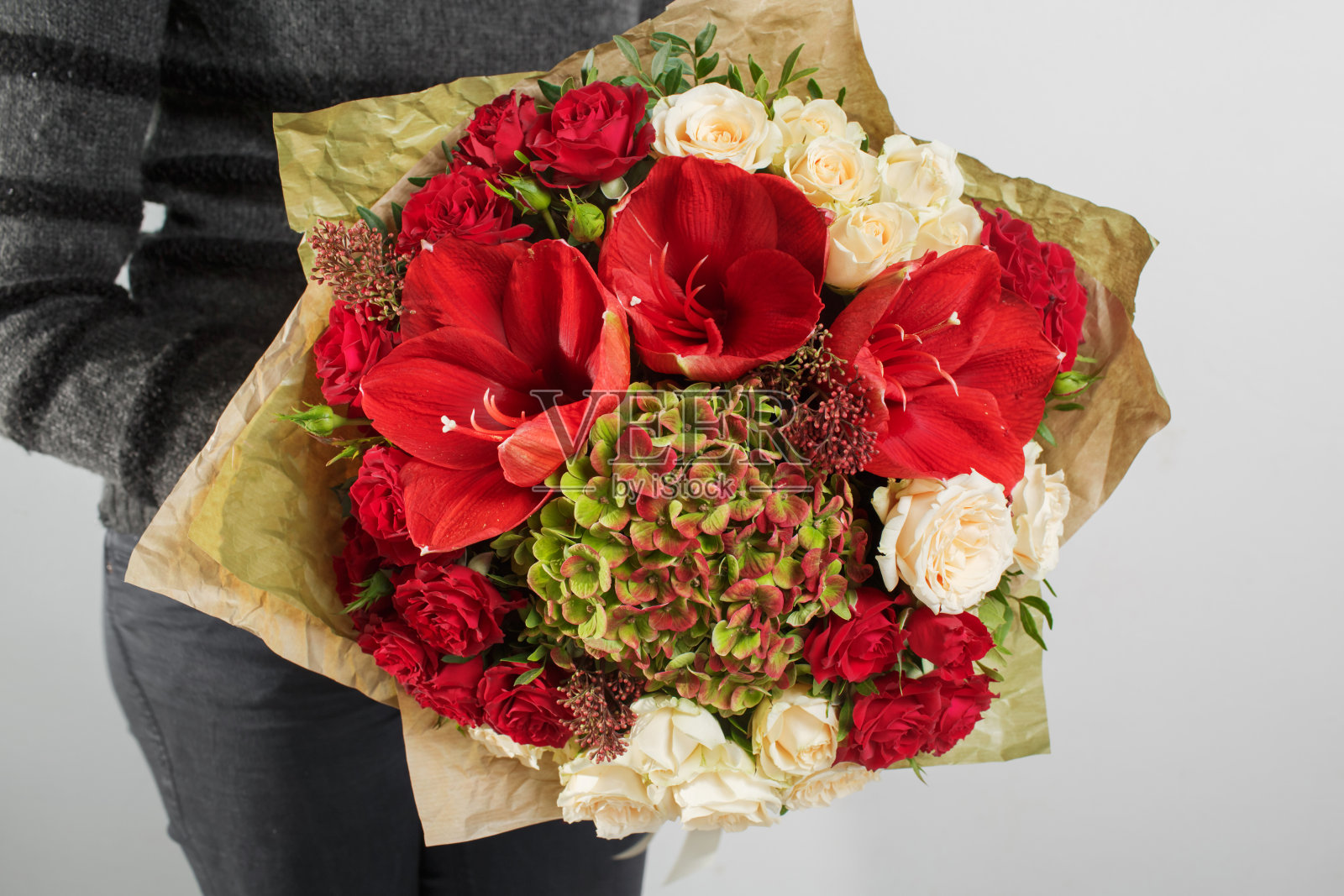 女人手里拿着绣球花的花束。五颜六色的玫瑰和各种颜色的花混搭照片摄影图片