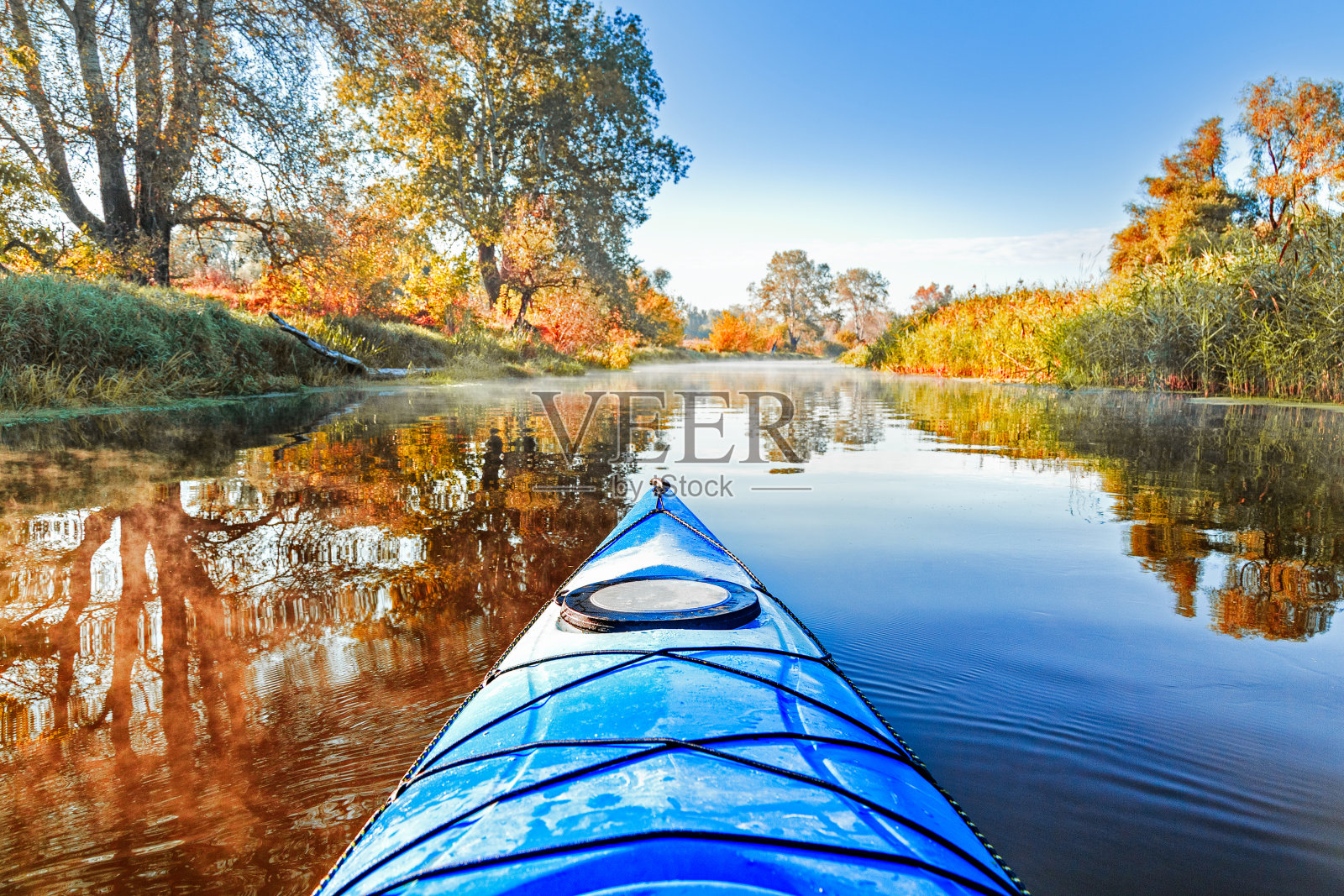 从蓝色的皮艇在河岸与秋天的黄叶树秋天季节。塞夫斯基顿涅茨河，秋季皮划艇。在亮蓝色皮艇的鼻子上方的视图。照片摄影图片