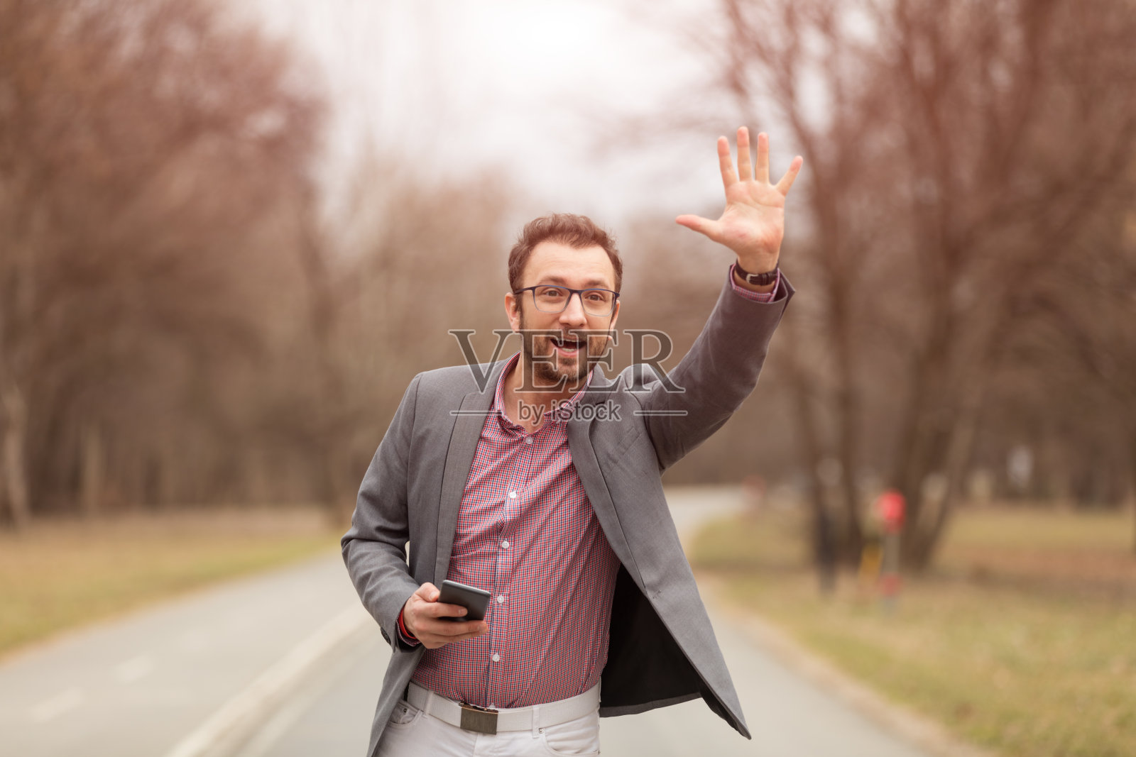 优雅的男人在户外使用手机。照片摄影图片