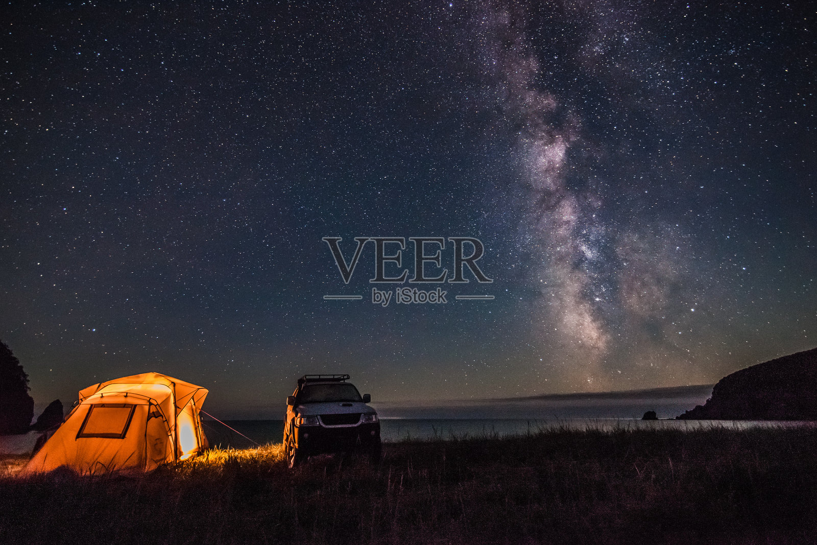 游客在海边露营晚上与银河照片摄影图片