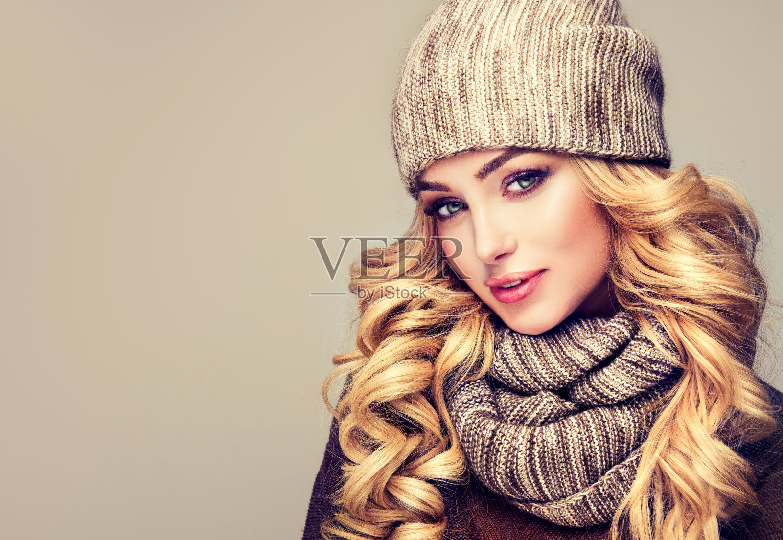 迷人的金发模特穿着时尚的针织冬装。照片摄影图片