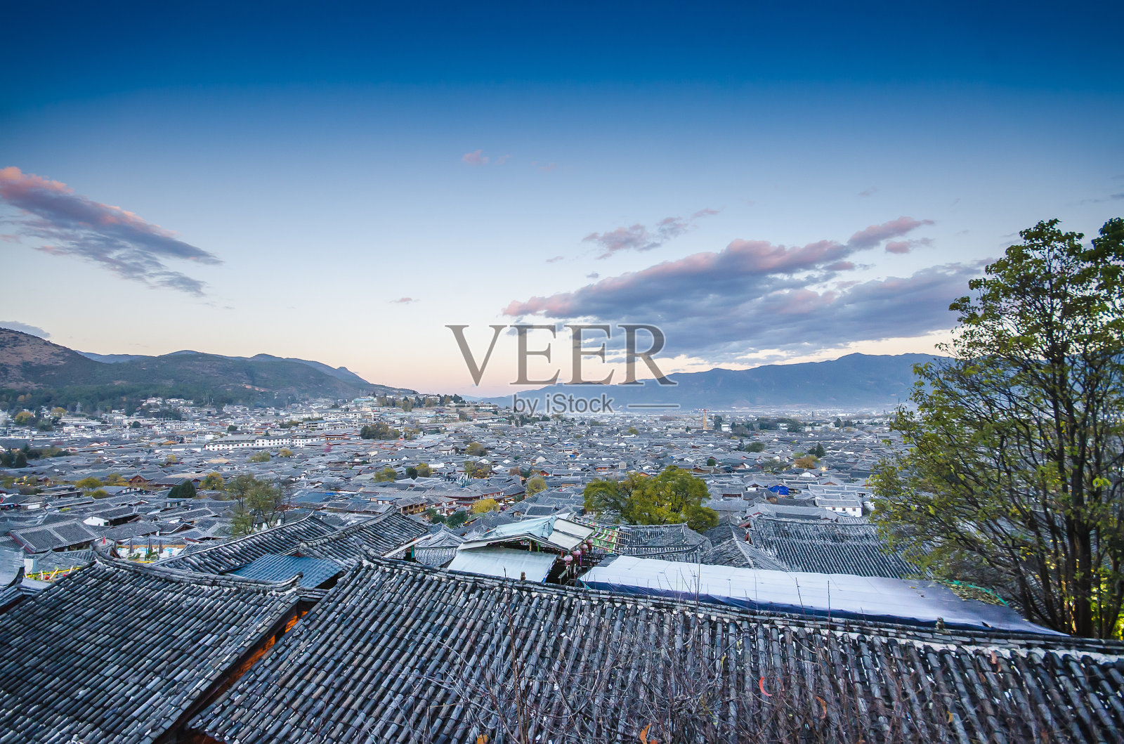 丽江古城鸟瞰，俯视着当地的历史建筑，屋顶建筑在暮色中照片摄影图片