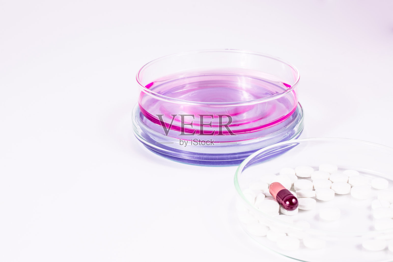 药物分析。皮氏培养皿中的药片和彩色液体。实验室，科学和临床背景。照片摄影图片
