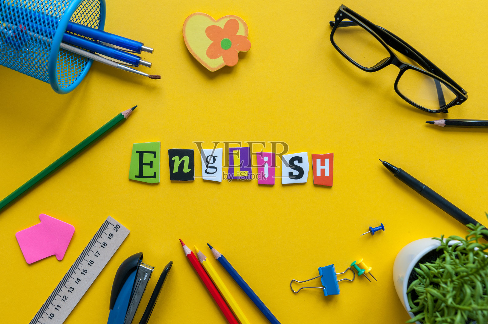 英语单词刻字在黄色背景上配办公或学习用品，英语语言学习概念照片摄影图片