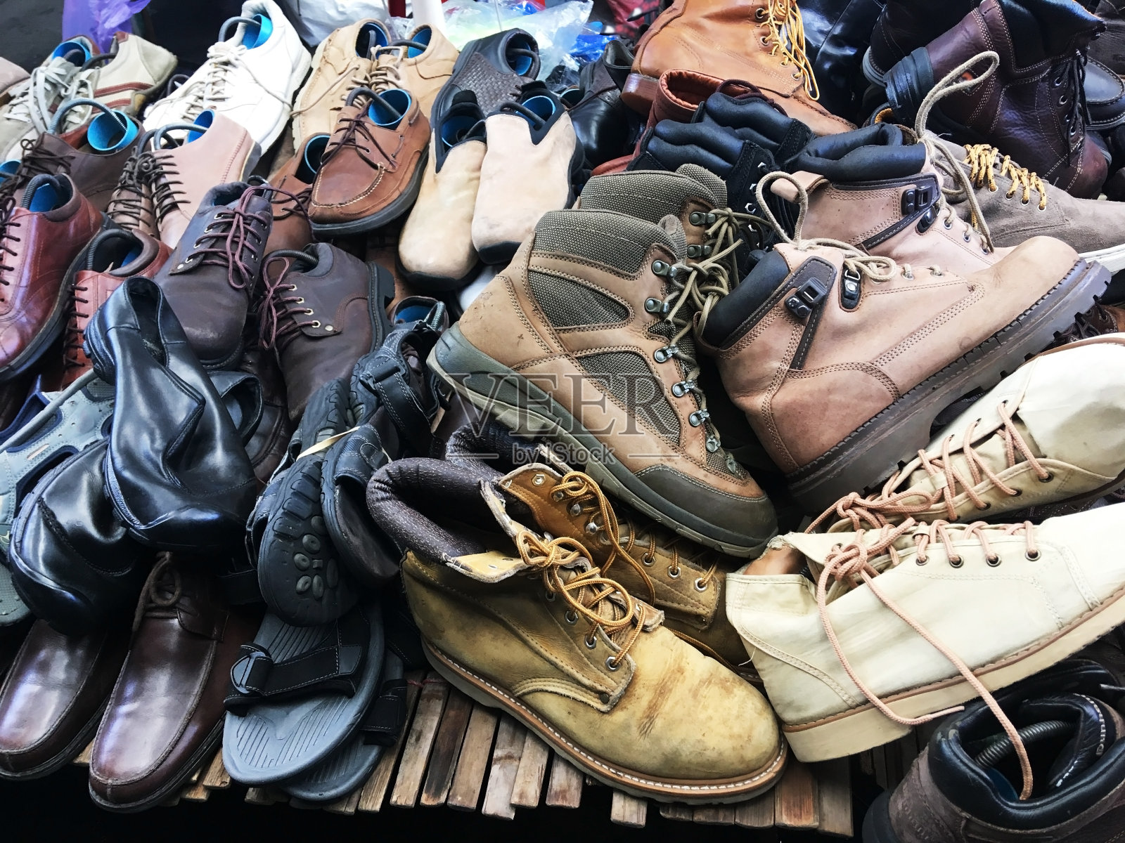 周末市场货架上的一堆二手鞋。照片摄影图片