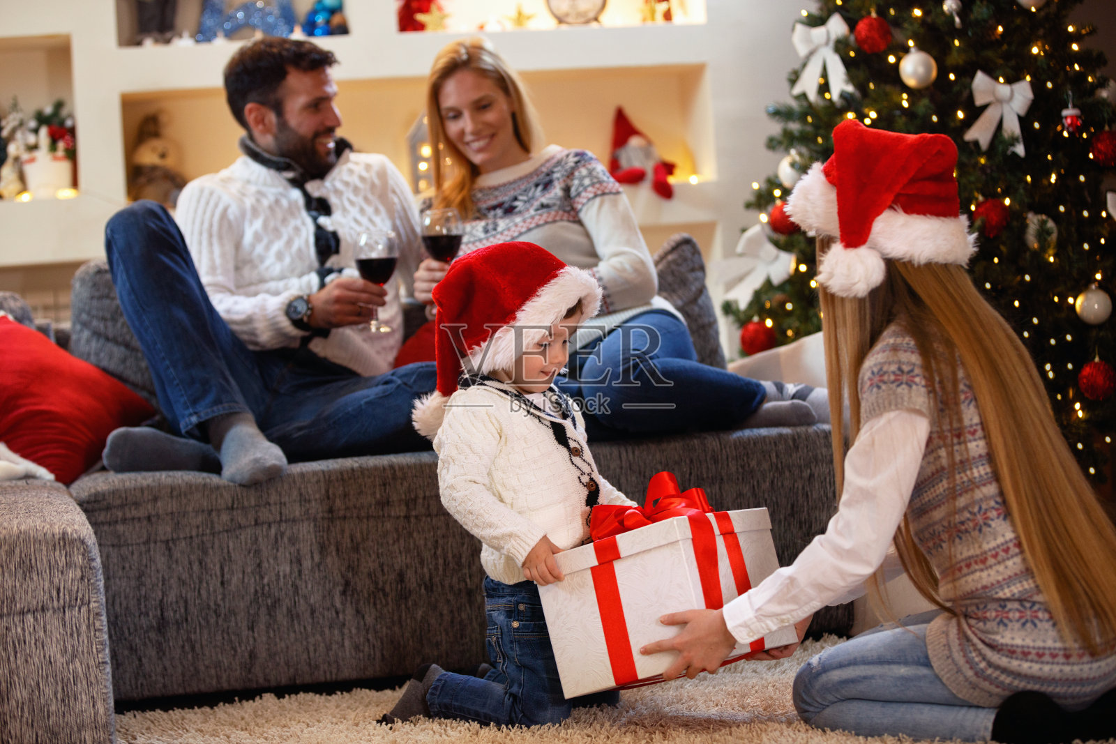 圣诞礼物——孩子们和家人一起打开礼物盒照片摄影图片