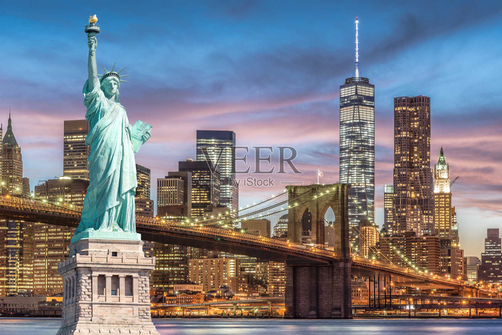 以世贸中心为背景的自由女神像和布鲁克林大桥，落日余晖，纽约市地标照片摄影图片