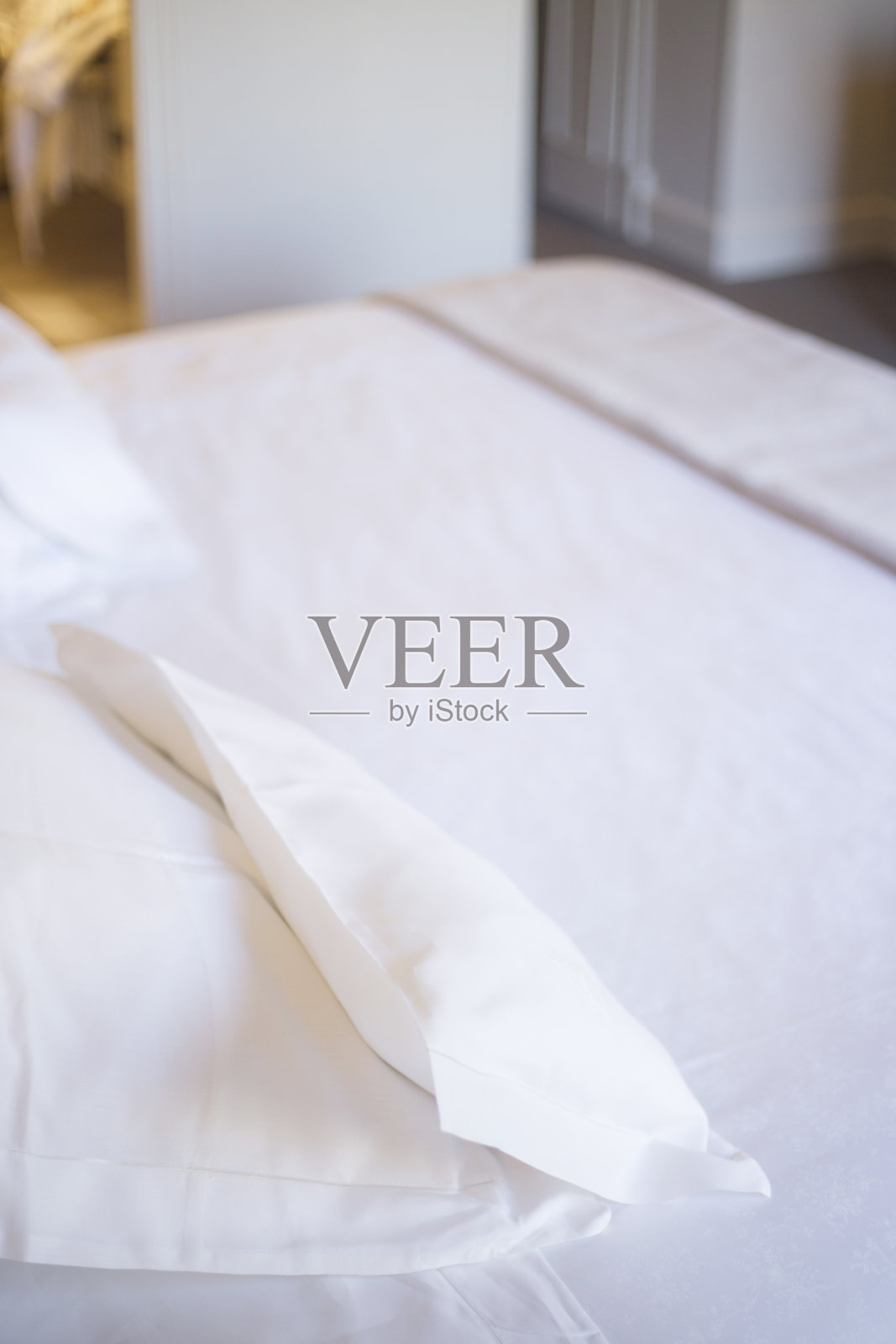 豪华酒店卧室的床干净熨烫整齐，棉质床单和枕头为客人准备好睡觉。照片摄影图片