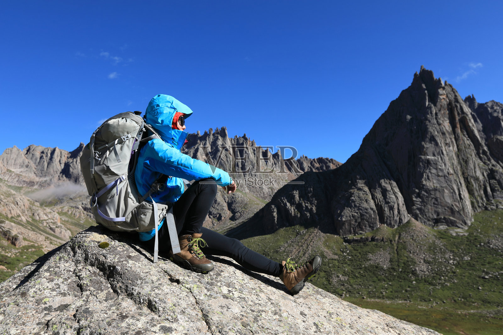 成功的女徒步旅行者欣赏山顶岩石上的景色照片摄影图片