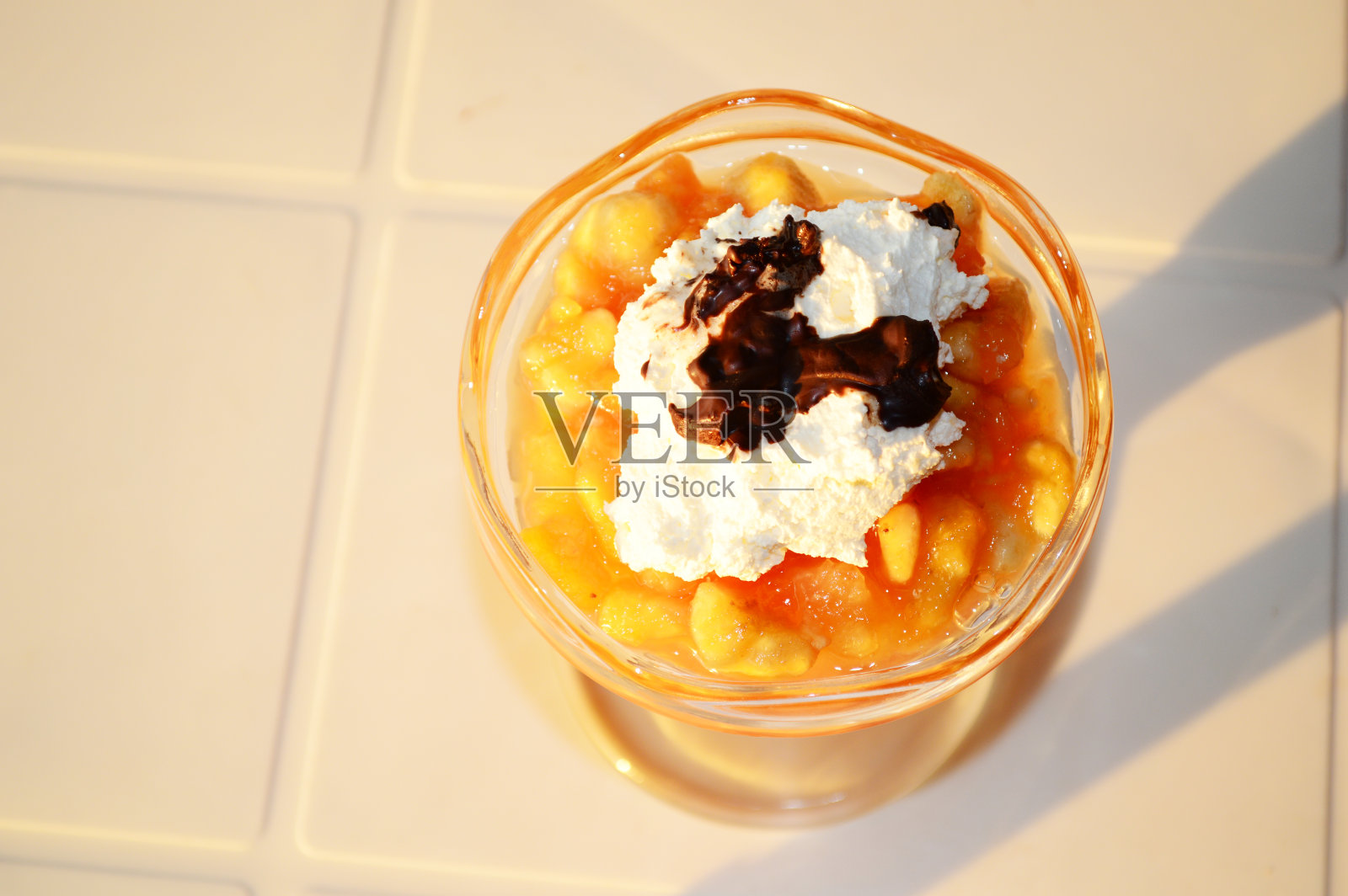 热带水果沙拉包括木瓜，菠萝，香蕉，酸奶和巧克力在水果杯照片摄影图片