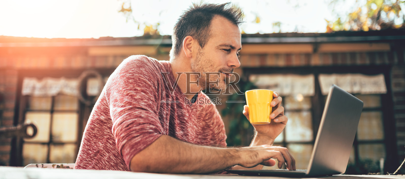 男人们在后院的院子里喝着咖啡，用着笔记本电脑照片摄影图片