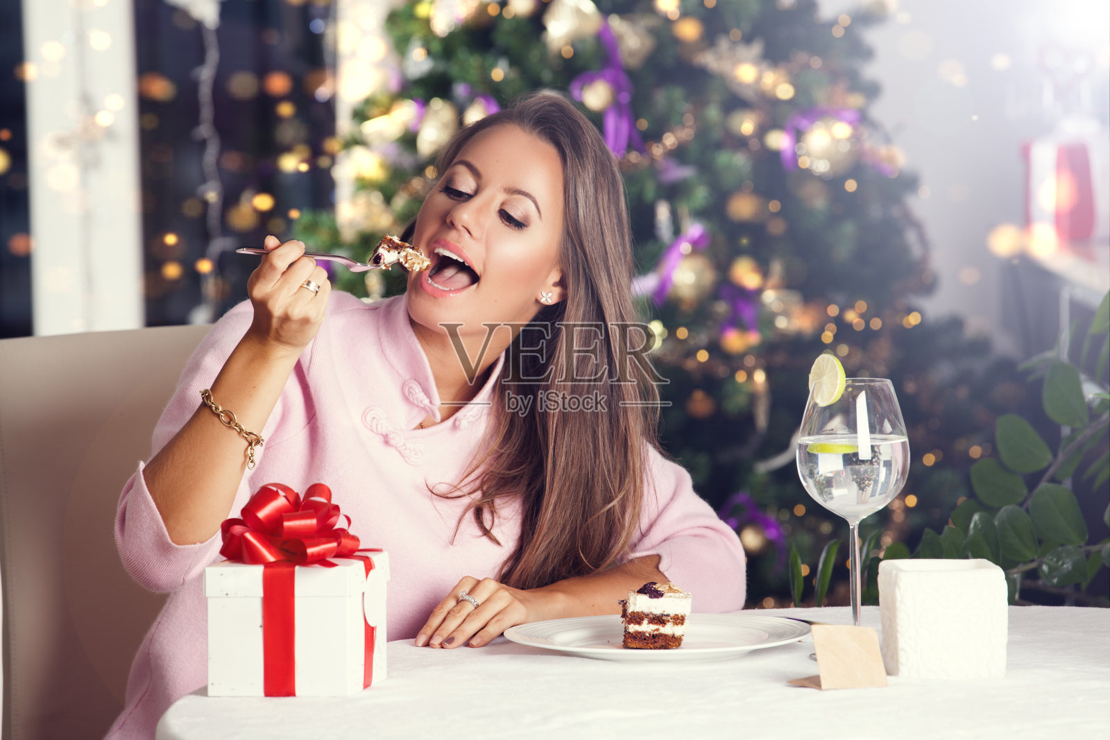 迷人的快乐的年轻女子吃甜点照片摄影图片