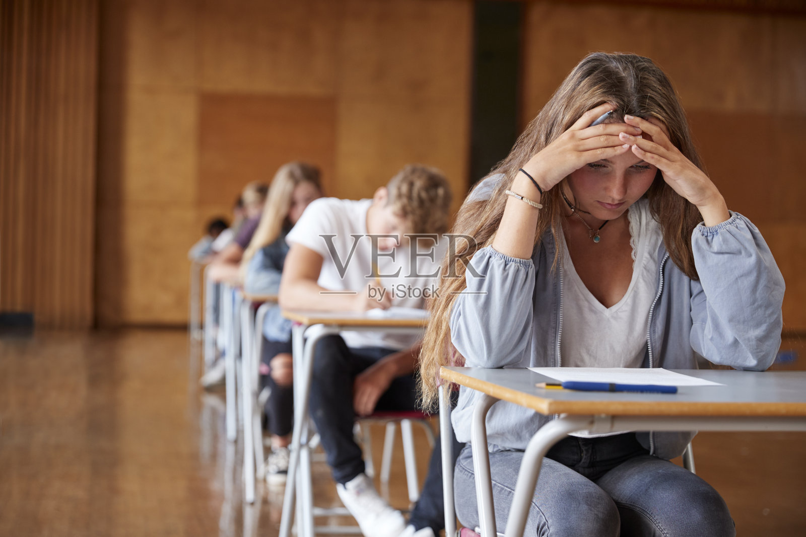 焦虑的青少年学生在学校礼堂考试照片摄影图片