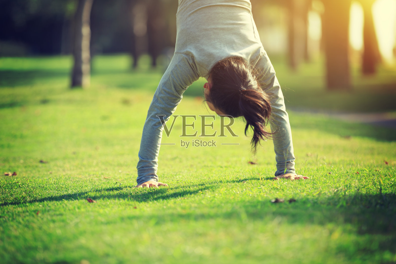 健康的生活方式妇女在公园草地上练习倒立照片摄影图片