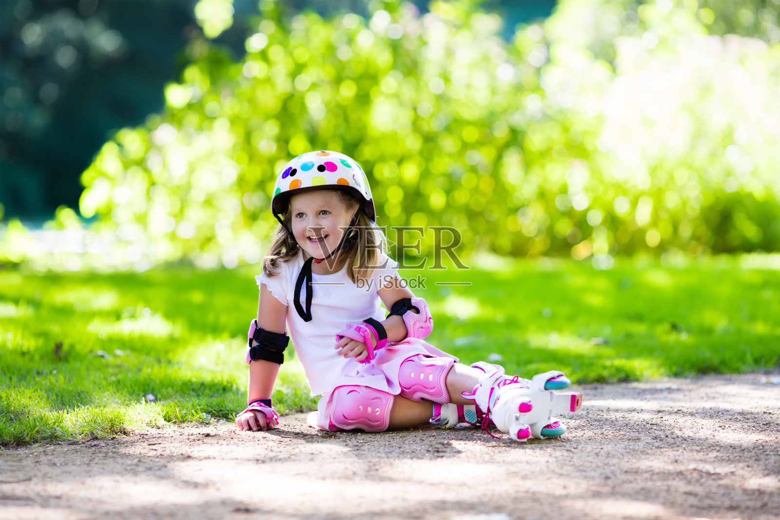 穿着溜冰鞋的小女孩在公园里照片摄影图片
