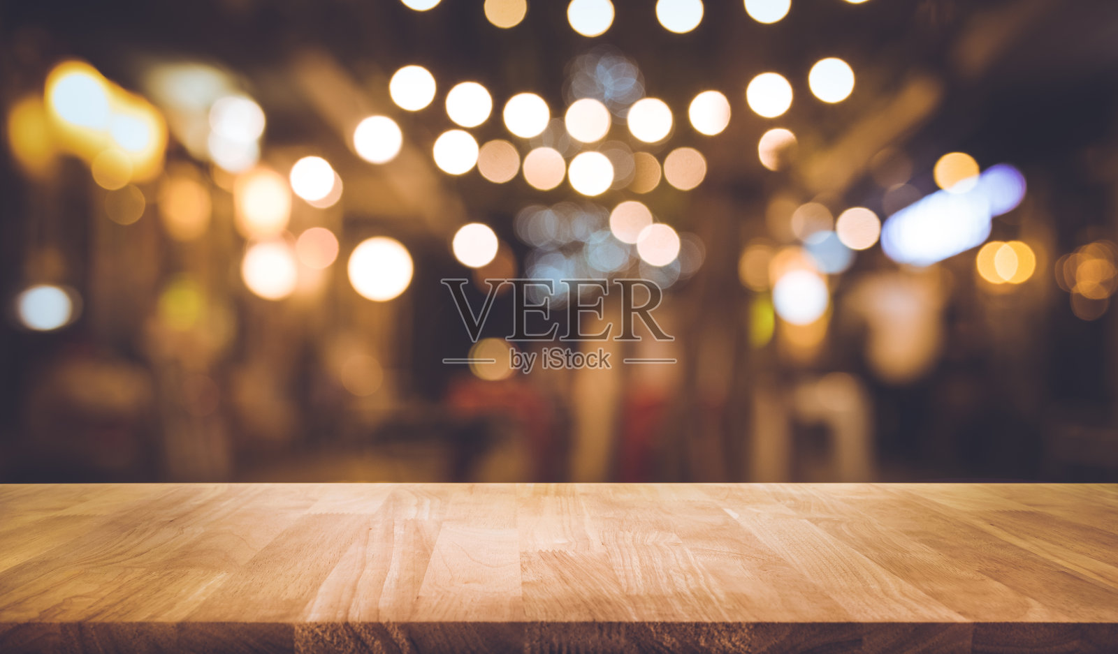 木条桌子与模糊的灯光在夜晚街头咖啡馆照片摄影图片