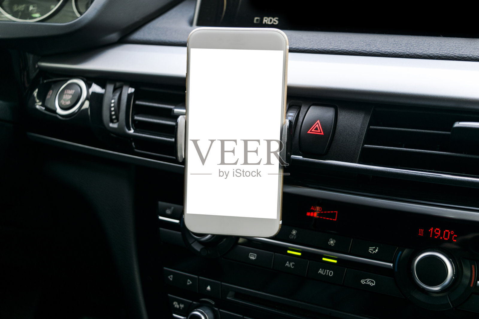 智能手机在汽车中使用导航或GPS。驾驶一辆装有智能手机的汽车。手机与隔离白色屏幕。空白的空屏幕。副本的空间。文本的空白。现代汽车内部细节。照片摄影图片