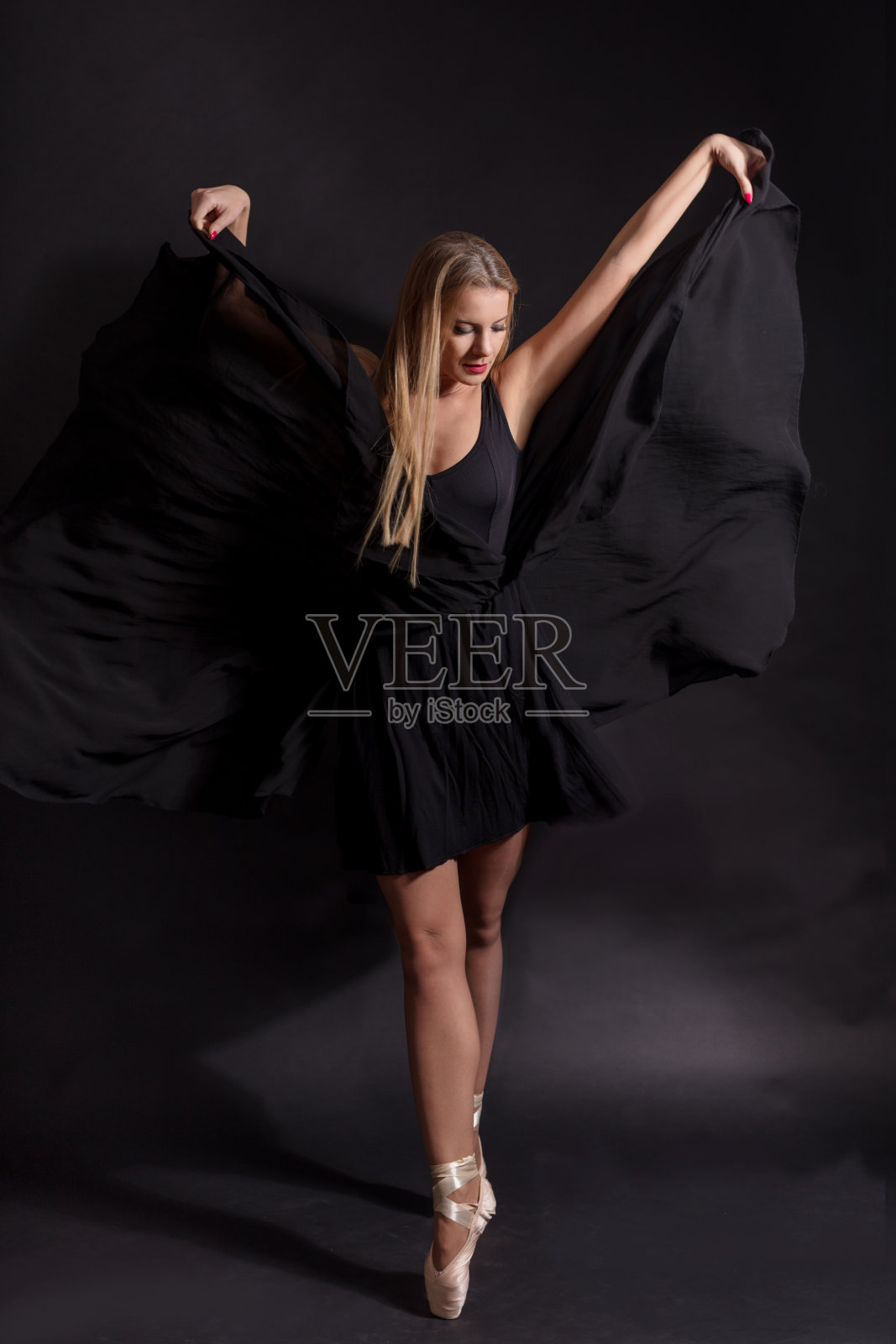 女芭蕾舞者在黑色背景下穿着黑色裙子跳舞照片摄影图片