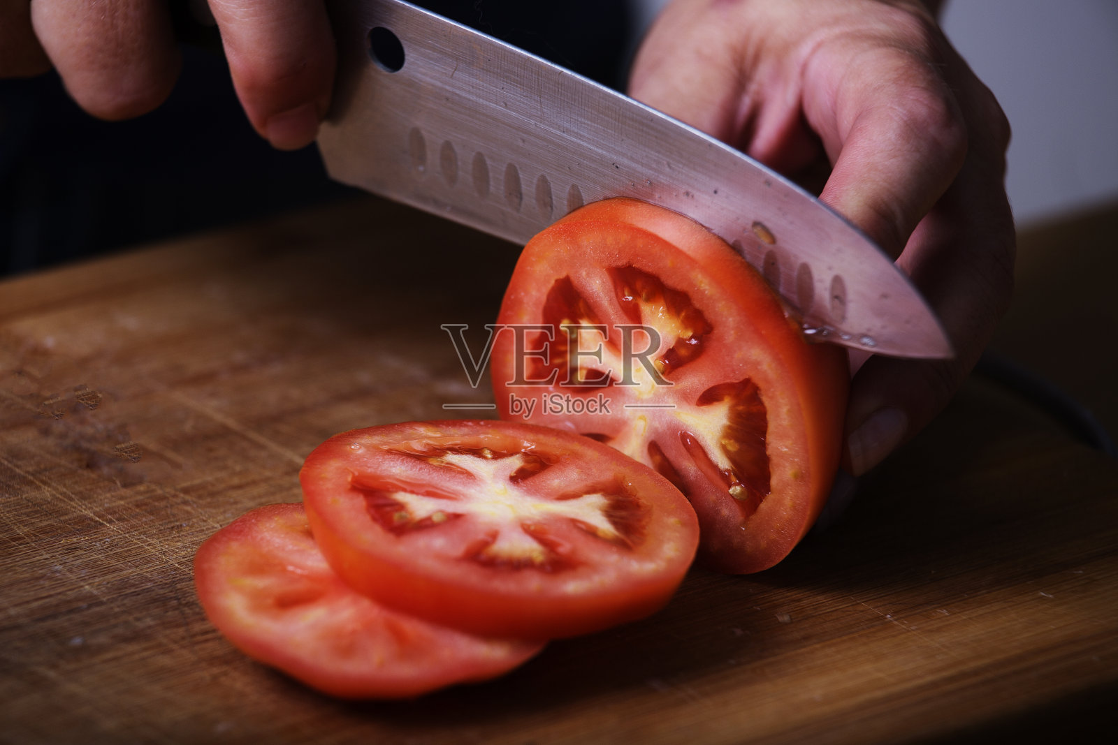 用锋利的刀把番茄切成片照片摄影图片
