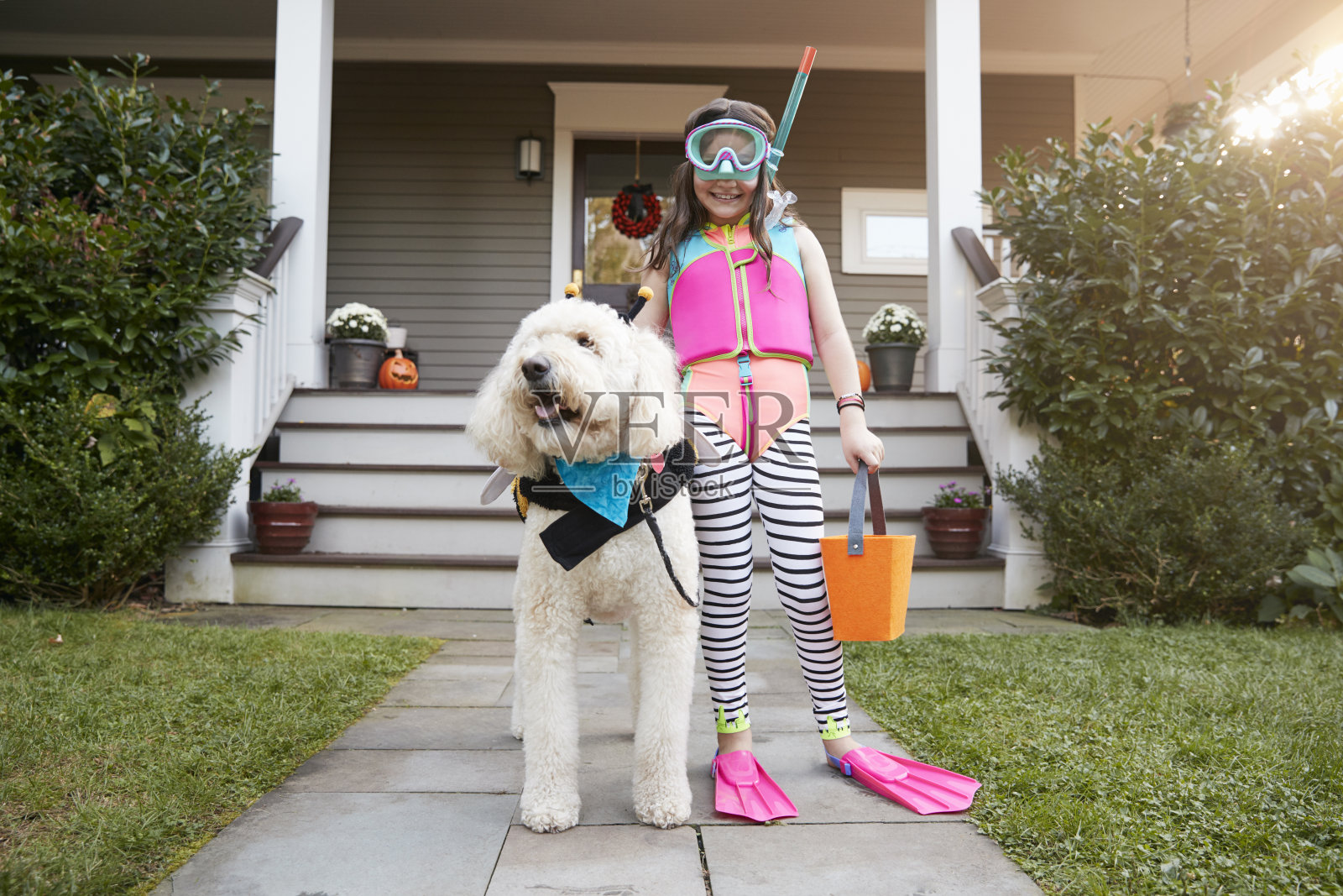 女孩与狗穿着万圣节服装的Trick Or Treating照片摄影图片