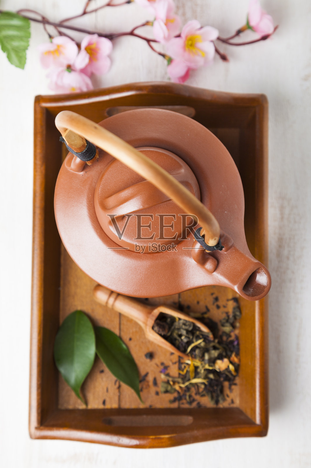 木制托盘上的陶瓷茶壶。照片摄影图片