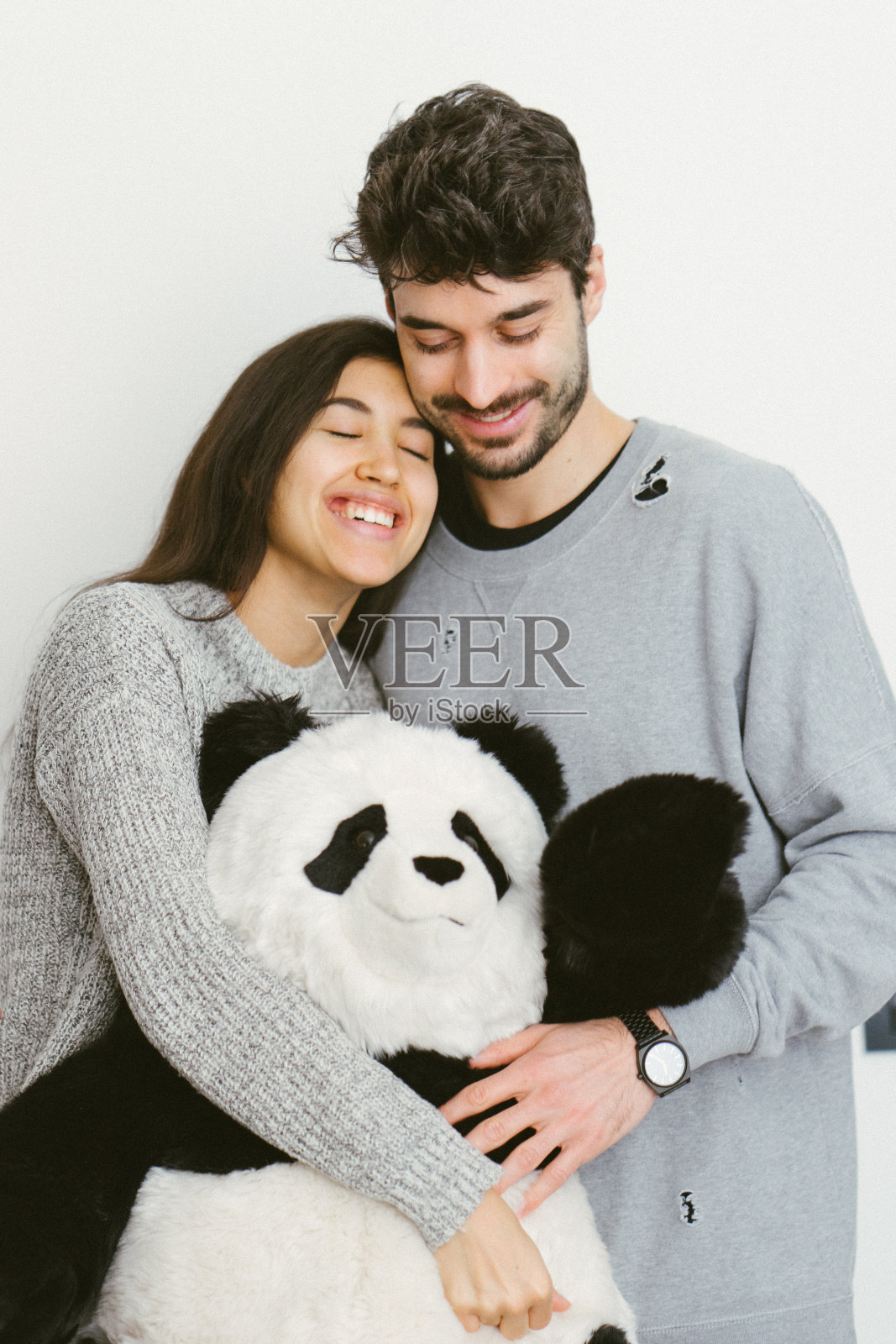 一对幸福的年轻夫妇拥抱着一个柔软的玩具照片摄影图片