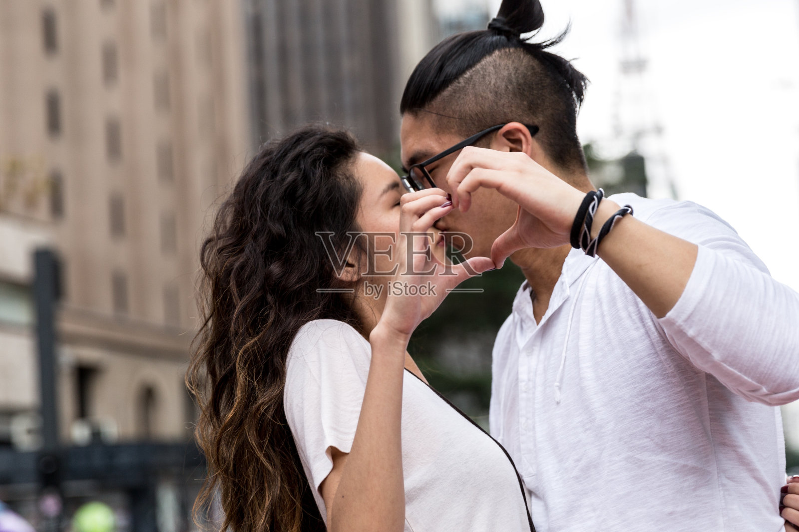 年轻的亚洲夫妇用他们的手做一个心形照片摄影图片