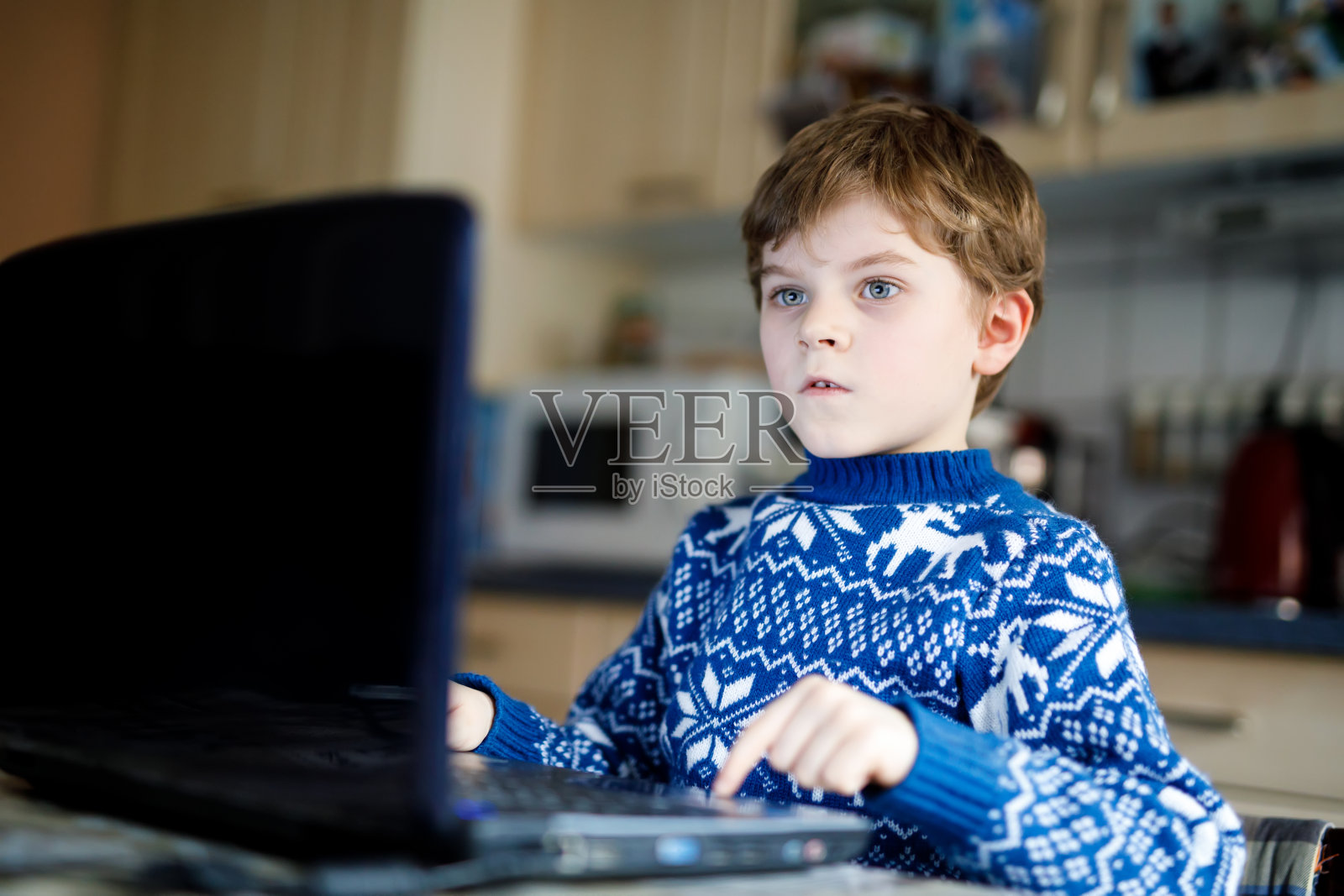 戴着眼镜的小男孩在电脑上做学前作业照片摄影图片
