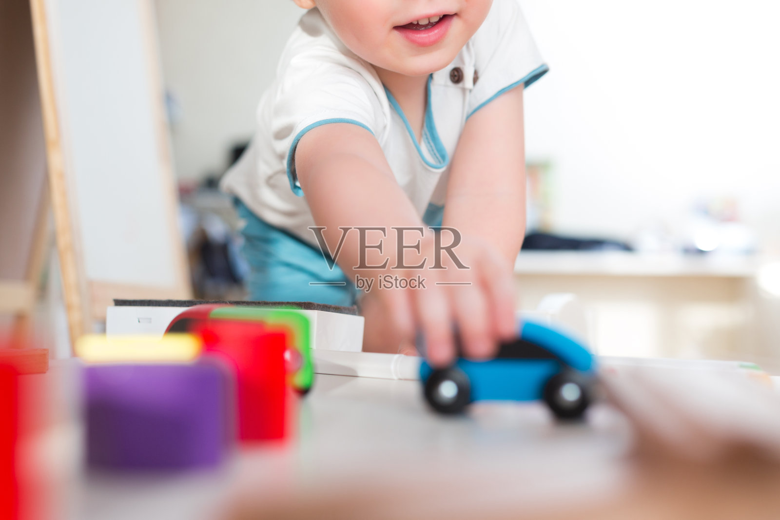两岁的小男孩玩木火车，在家搭玩具火车。蹒跚学步的男孩玩汽车。学前班和幼儿园儿童教育玩具，室内游乐场，生活理念照片摄影图片