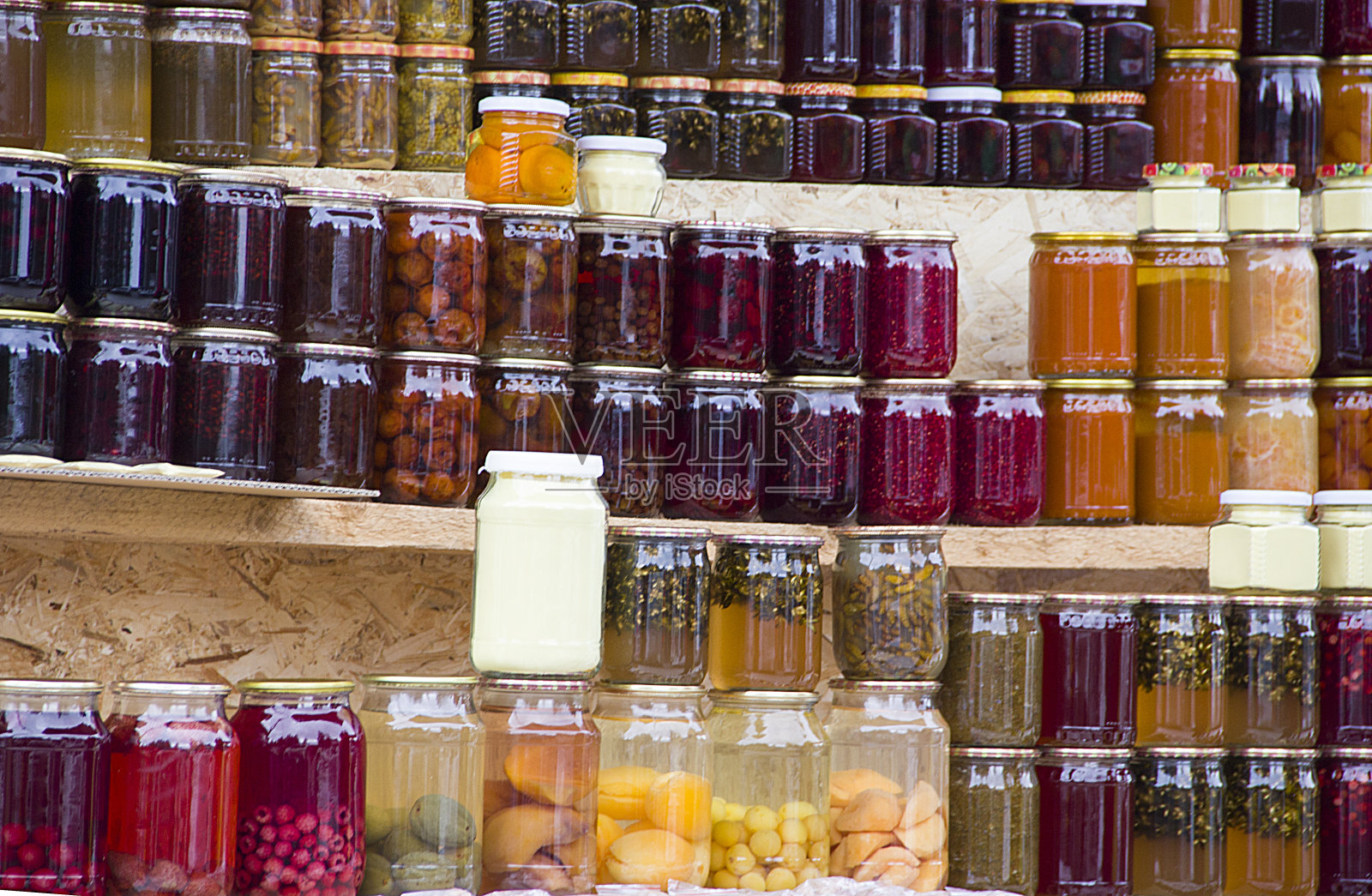 果盘，果酱，果酱和传统格鲁吉亚酱，浆果，水果和蔬菜在家。街边市场货架上的玻璃罐和瓶子装的罐头食品。照片摄影图片