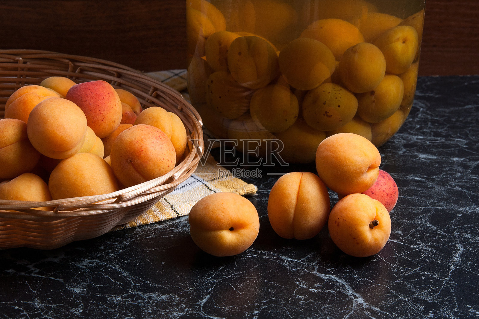 收获的杏在篮子和罐子与杏罐头蜜饯照片摄影图片