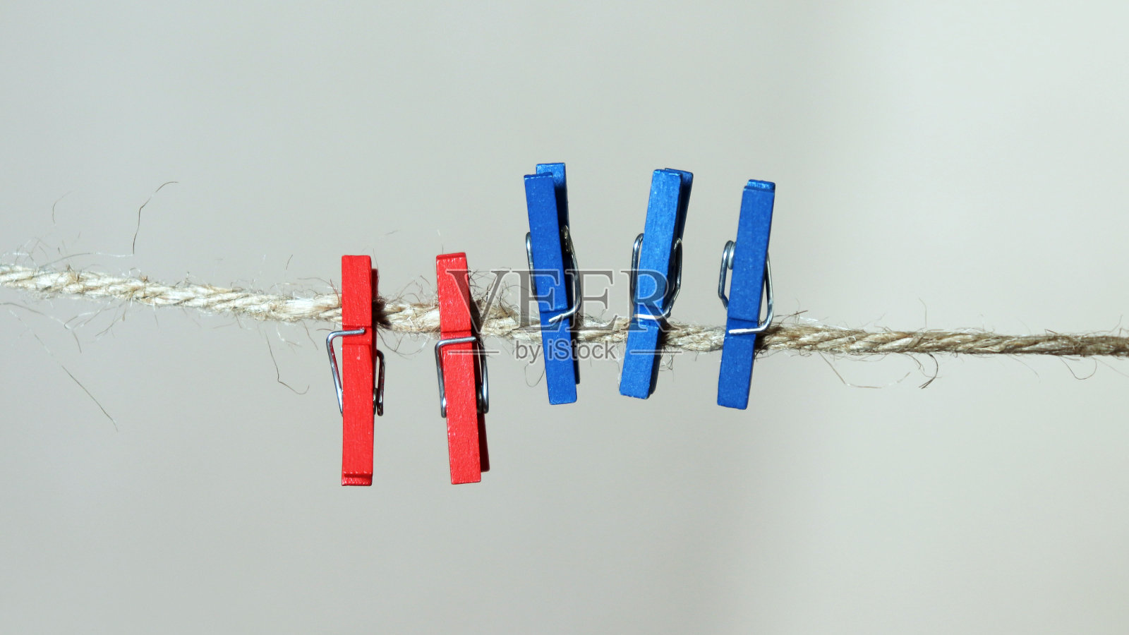 绳子上有三个蓝色洗衣夹和两个红色洗衣夹。照片摄影图片