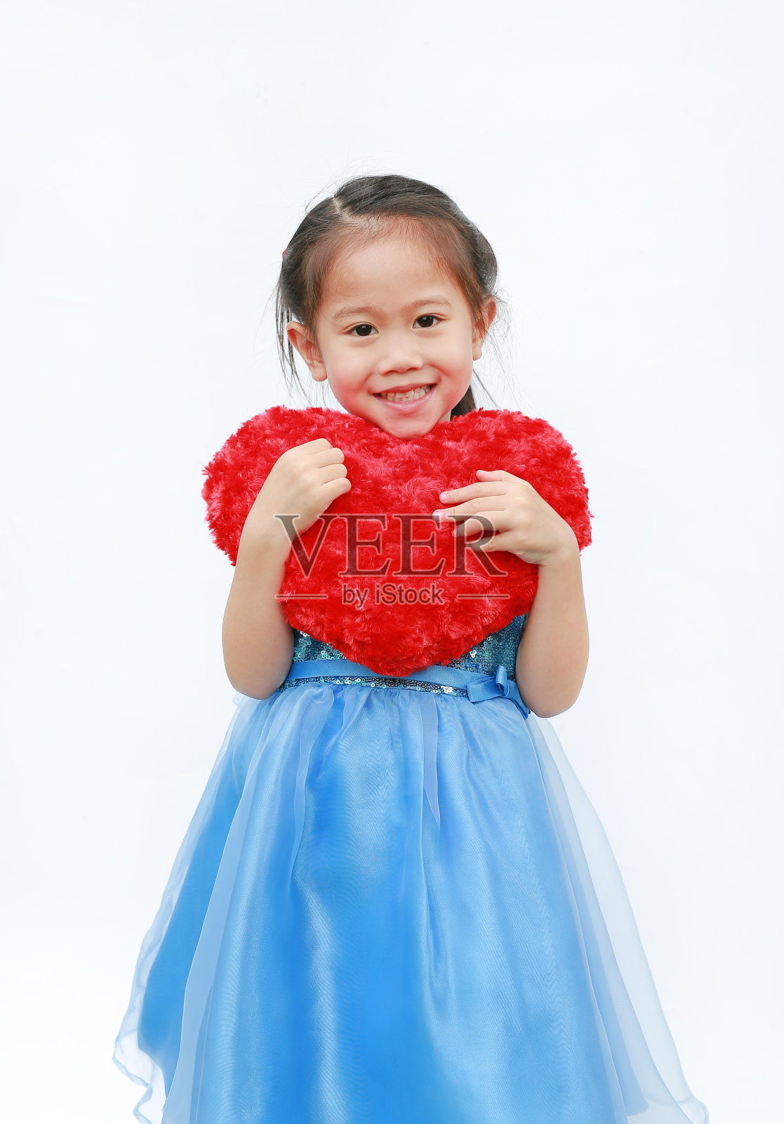 一个可爱的亚洲小女孩的肖像与红色的情人节心孤立在白色的背景。照片摄影图片