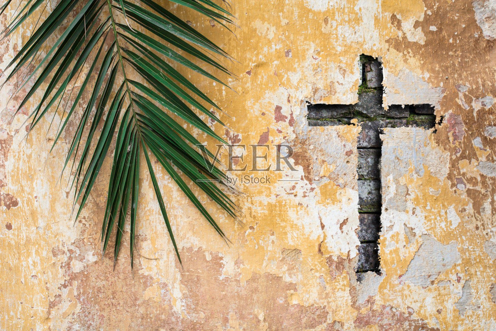 棕榈枝和基督教十字架或十字架在古老的传统墙上照片摄影图片