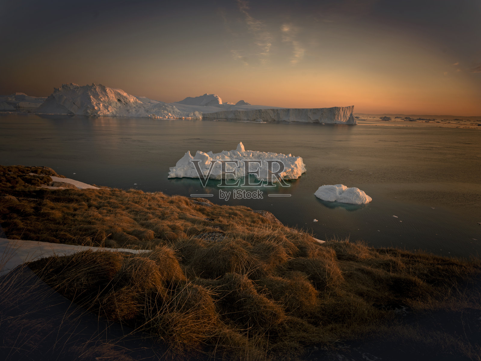 格陵兰岛日落时北冰洋上的冰山照片摄影图片
