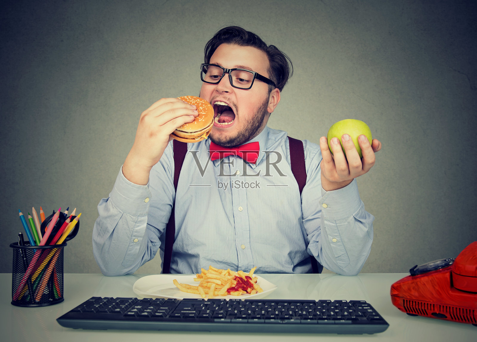 肥胖员工在工作场所吃快餐照片摄影图片