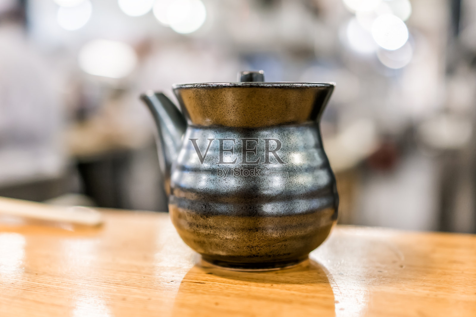 宏观特写的传统黑土日本茶壶茶壶陶瓷在木桌上的咖啡馆餐厅孤立照片摄影图片