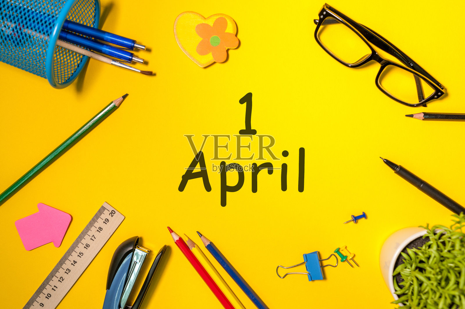 愚人节——4月1日。4月1日，日历在黄色课桌的背景上。春天的时间照片摄影图片