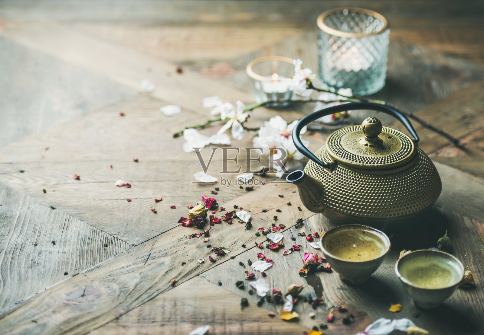 铁茶壶，杯子，干玫瑰花蕾和蜡烛，复印空间照片摄影图片