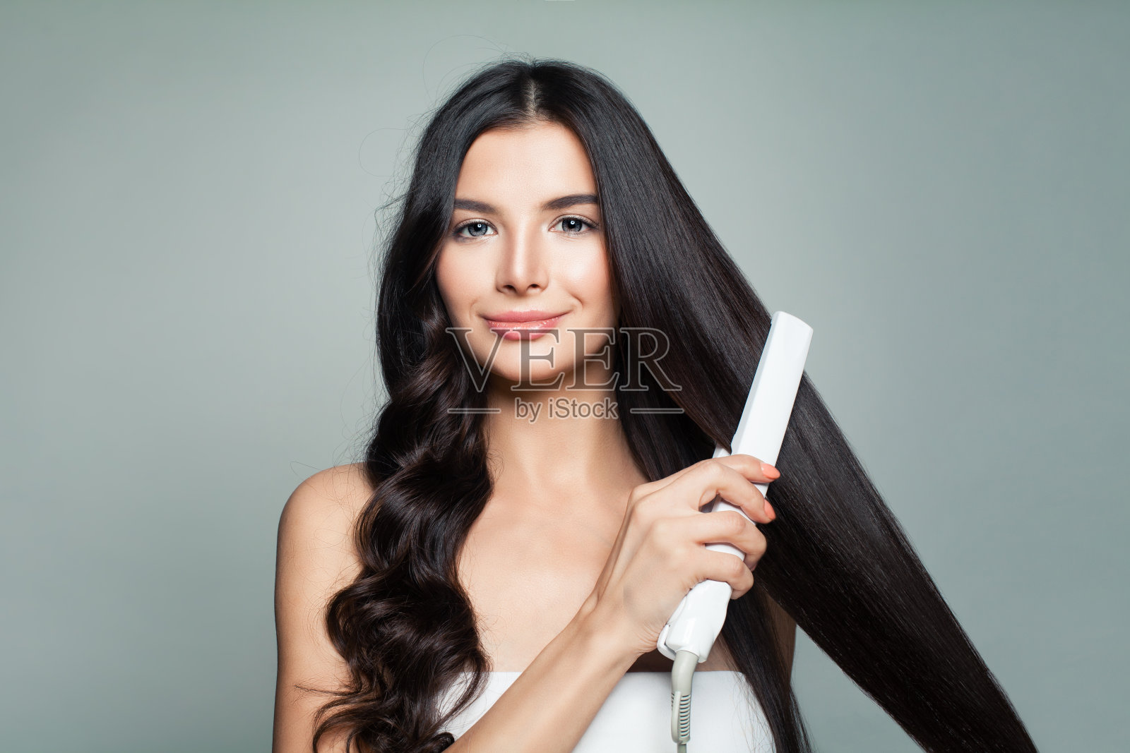 有吸引力的女人与卷发和长直发使用直发器。头发问题和护发概念照片摄影图片
