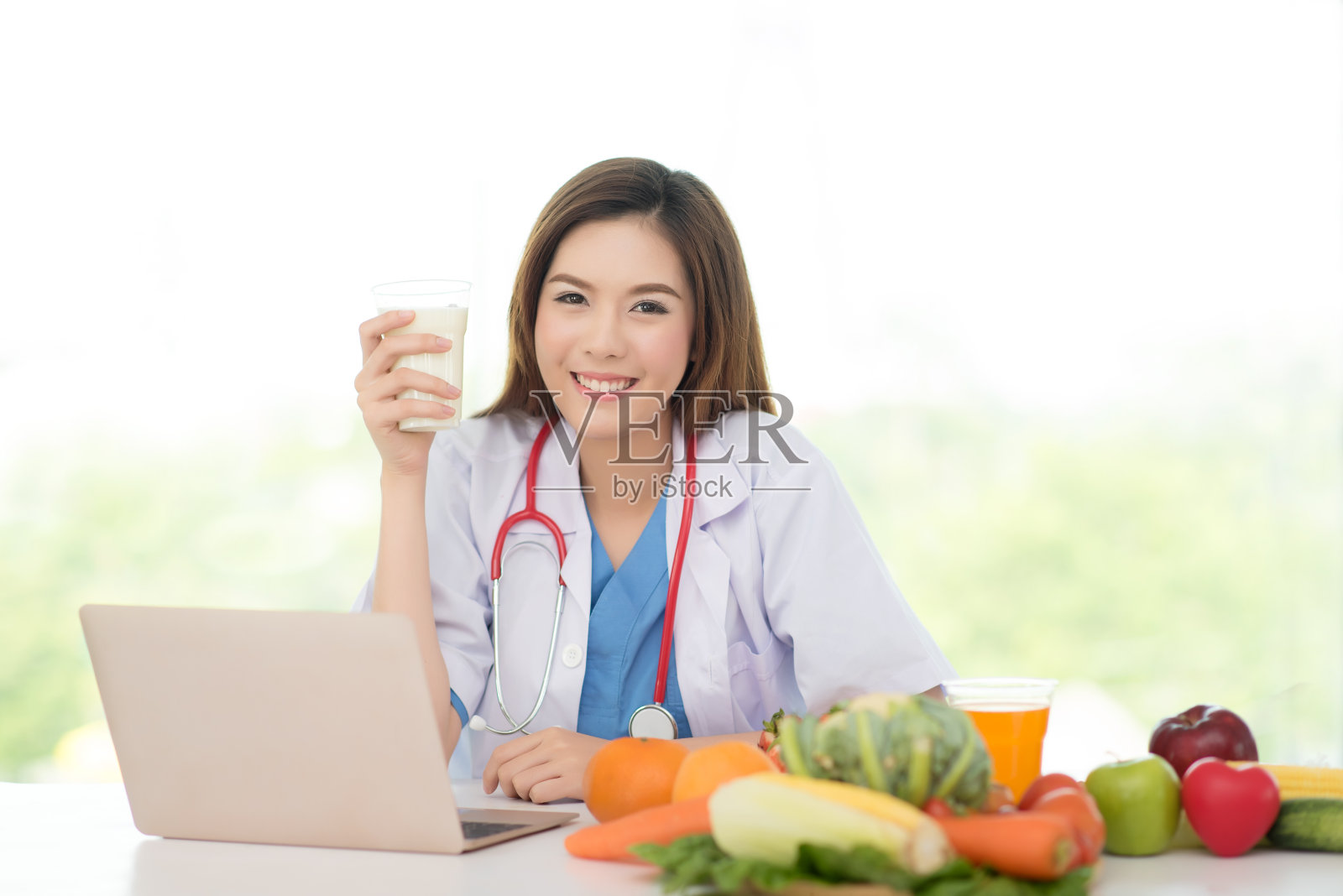 专业的营养医生，提供健康的水果，食品和饮料。她提出了一杯高钙牛奶的营养和饮食保健概念照片摄影图片
