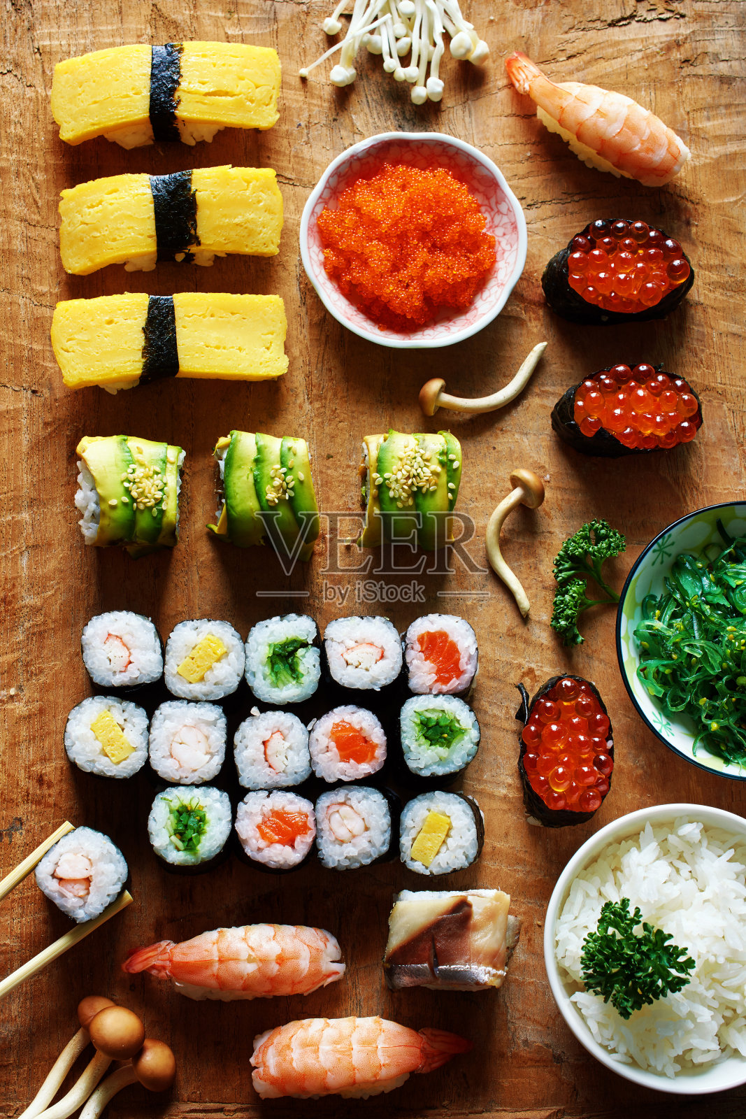 什锦寿司，一碗米饭，裙带菜和tobiko，木桌蘑菇。照片摄影图片