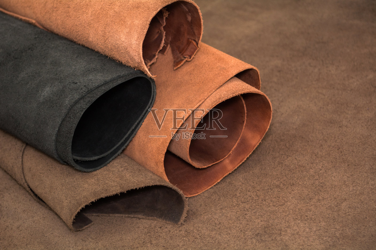 天然棕色和黑色皮革卷。皮革工艺材料照片摄影图片