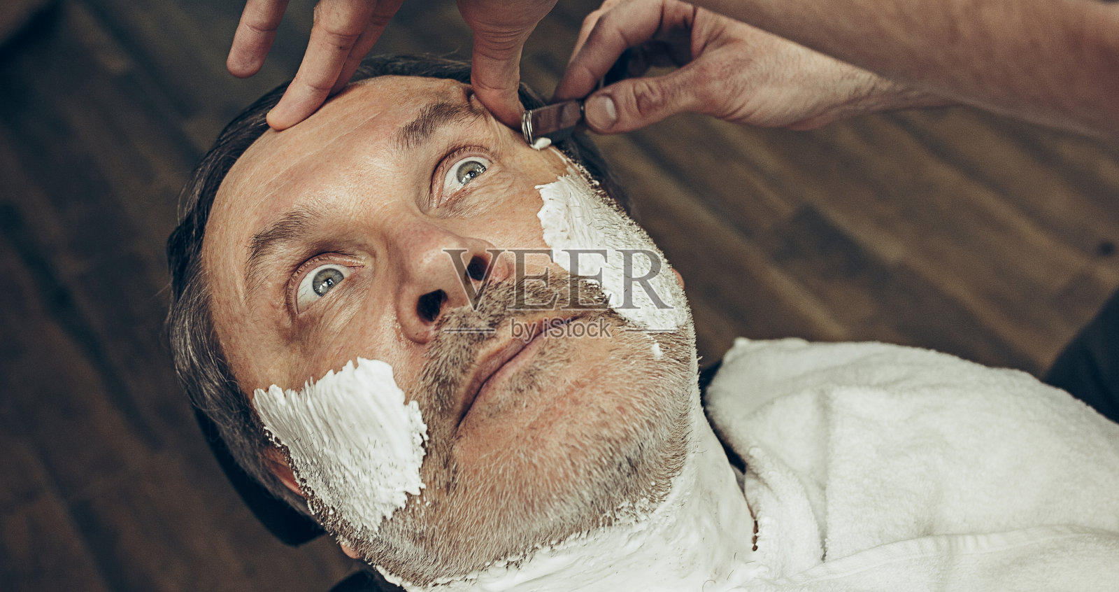 特写侧顶视图英俊的资深胡须白种人得到胡子美容在现代理发店照片摄影图片