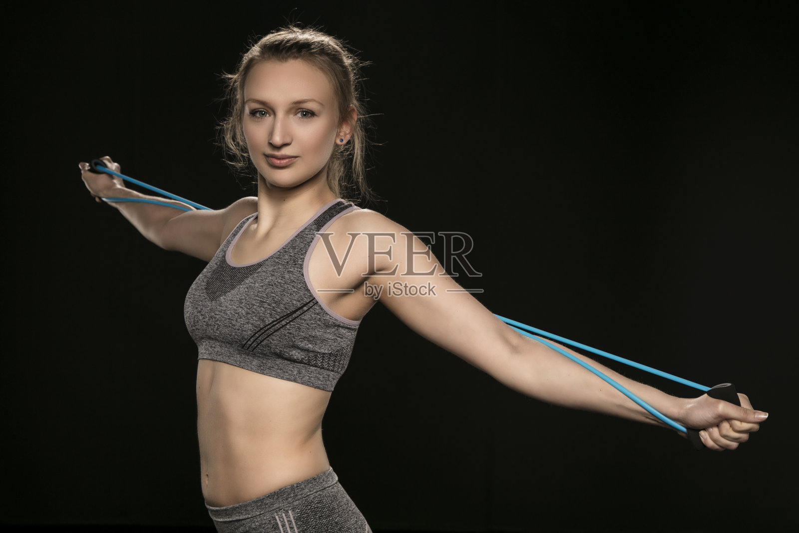 运动女孩用柔韧的绳子伸展和锻炼身体照片摄影图片