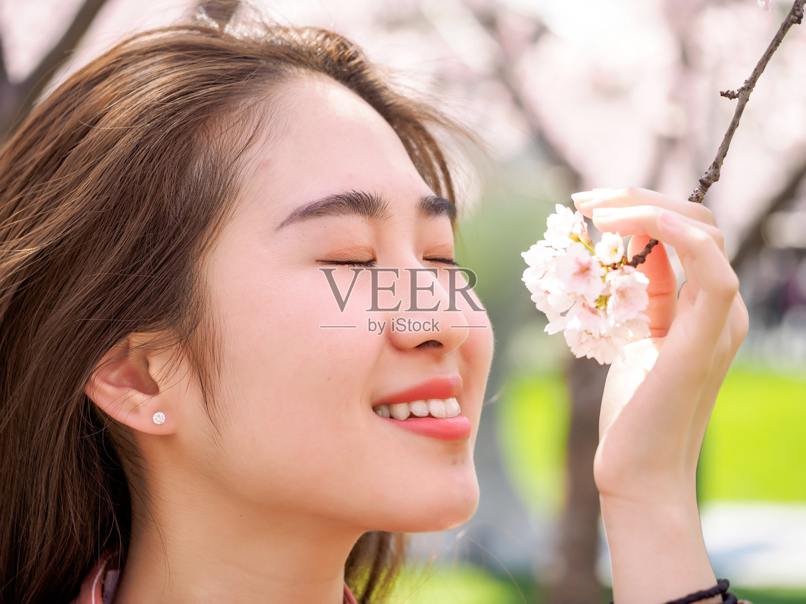户外肖像美丽的年轻的中国女孩在春天的花园樱花树早午餐微笑，美丽，夏天，情感，表达和人们的概念。照片摄影图片