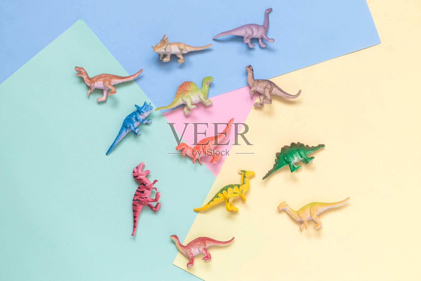 彩色背景上的小恐龙，简约的概念。照片摄影图片