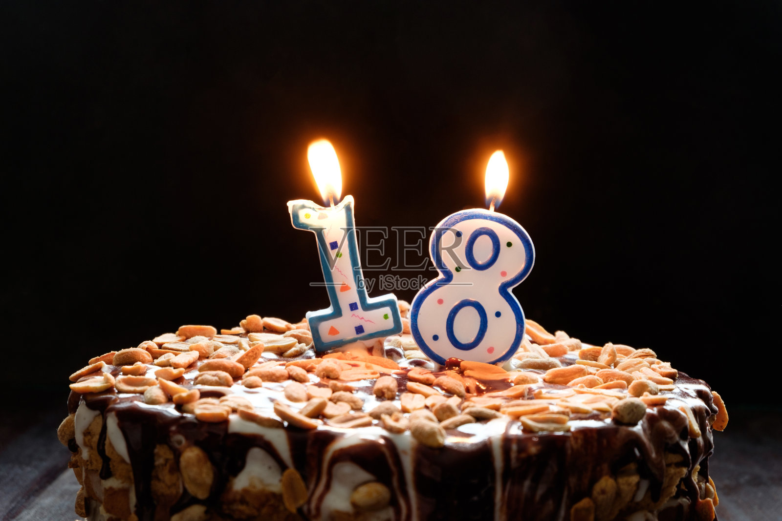 黑色背景上的生日蛋糕上两支燃烧的蜡烛照片摄影图片