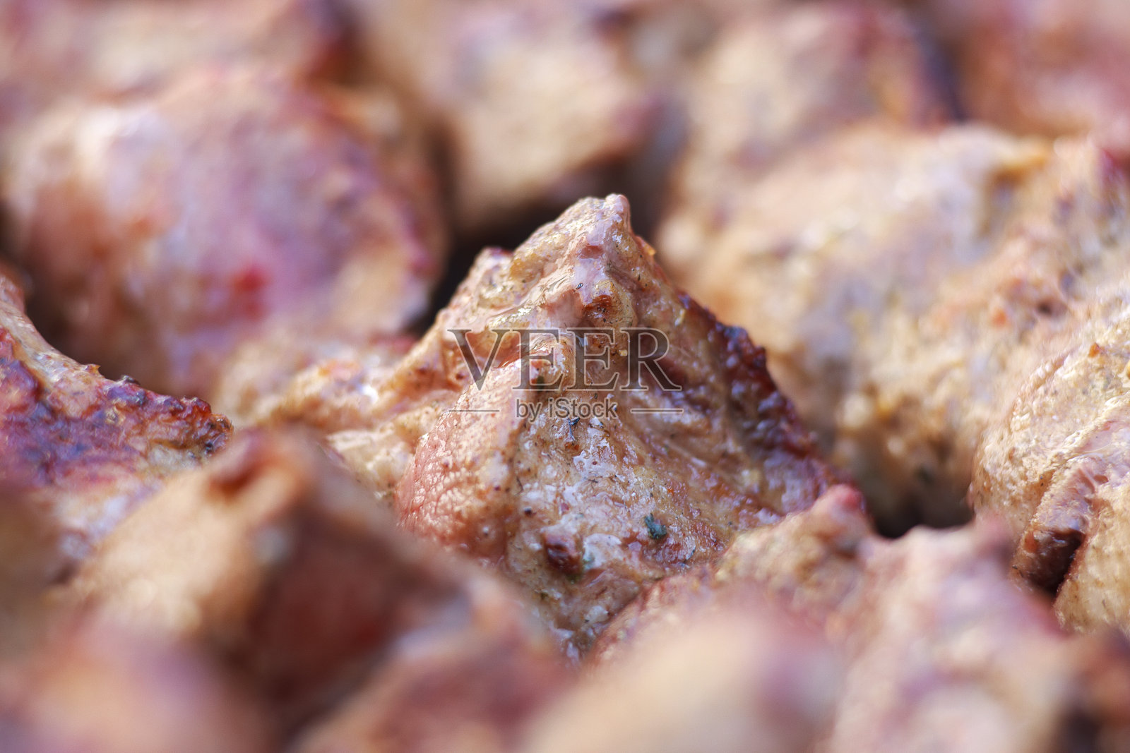 鲜美多汁的肉块，用木炭烤架烤串。把肉靠近点烤照片摄影图片