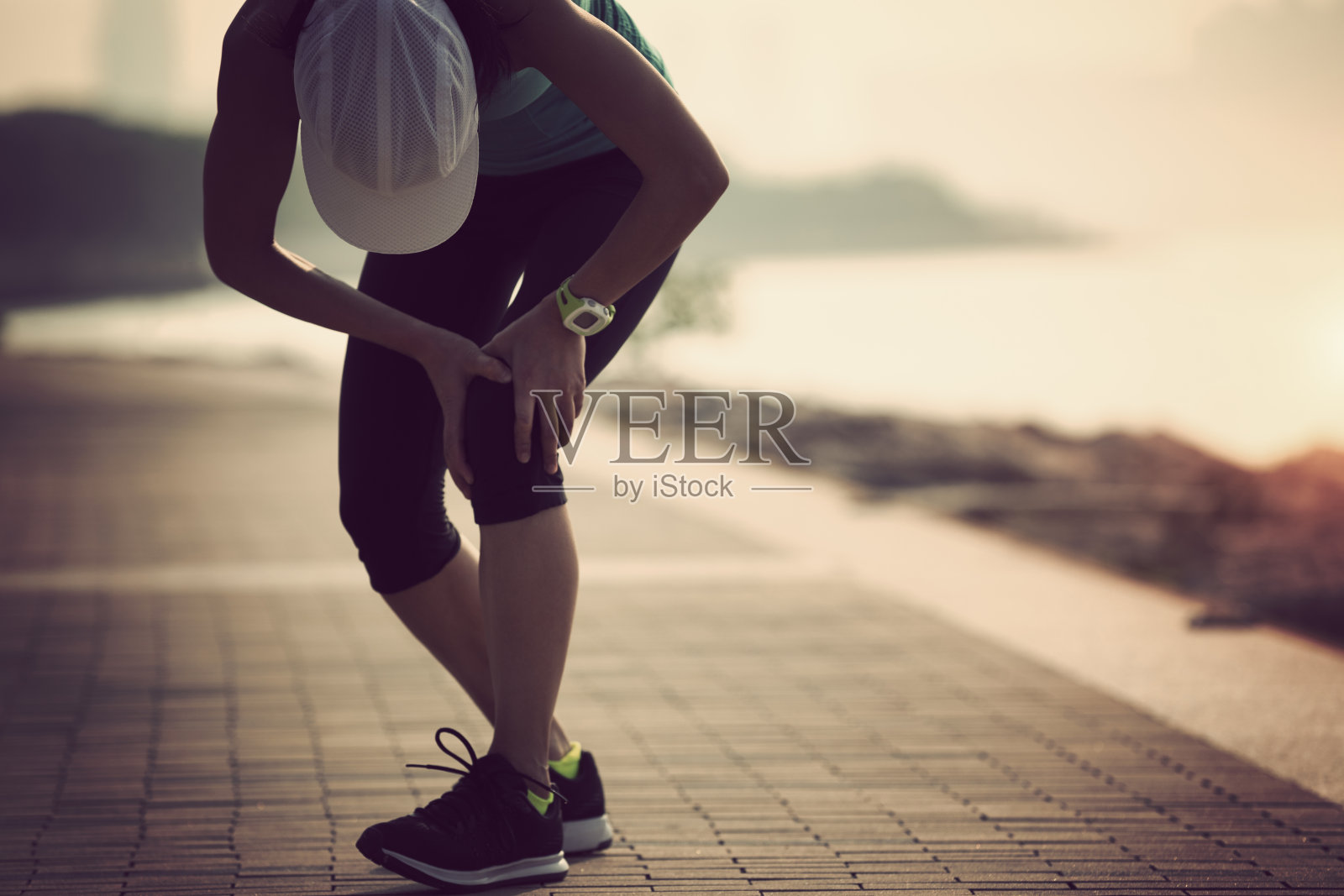 女跑步运动员扶着运动中受伤的膝盖照片摄影图片_ID:162987673-Veer图库